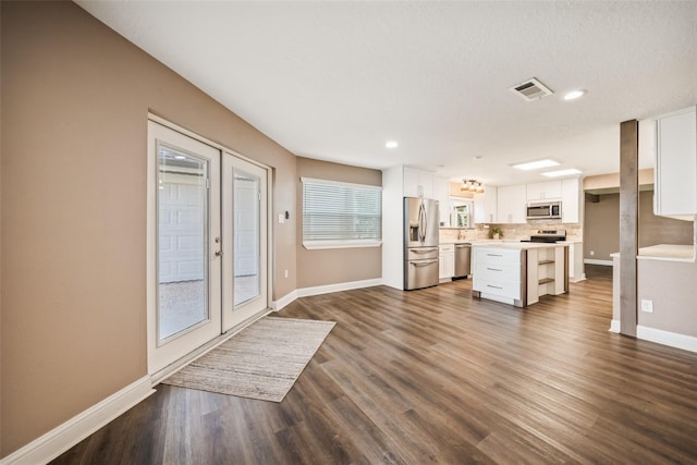 3019 Ramblewood Rd, Montgomery, TX 77356 - kitchen with appliances with stainless steel finishes, white cabinetry, light countertops, decorative backsplash, and dark wood-type flooring