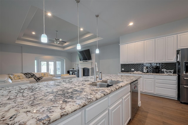 7707 Leighton Trl, Pasadena, TX 77505 - kitchen featuring open floor plan, dishwasher, a ceiling fan, decorative backsplash, and white cabinets