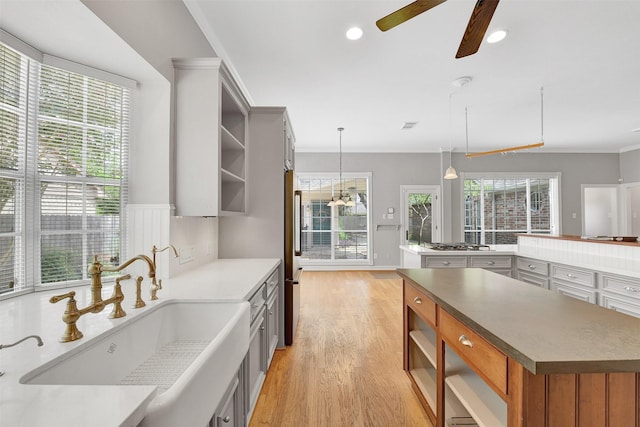 3519 E Pine Brook Way, Houston, TX 77059 - kitchen with open shelves, a spacious island, a ceiling fan, light wood-style floors, and crown molding