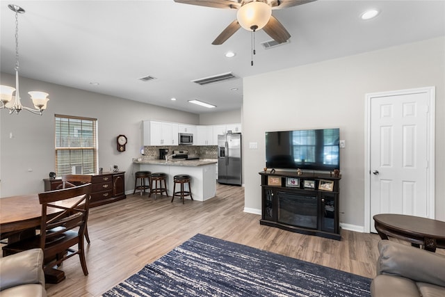 16887 Balmoral St, Montgomery, TX 77316 - living area featuring a chandelier, light wood finished floors, ceiling fan, and recessed lighting