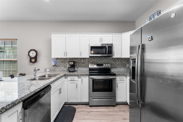 16887 Balmoral St, Montgomery, TX 77316 - kitchen with stainless steel appliances, white cabinets, backsplash, and light stone counters