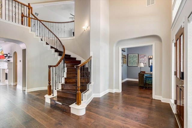 5822 Bailey Springs Ct, Katy, TX 77450 - entrance foyer with arched walkways, a high ceiling, wood finished floors, and stairway