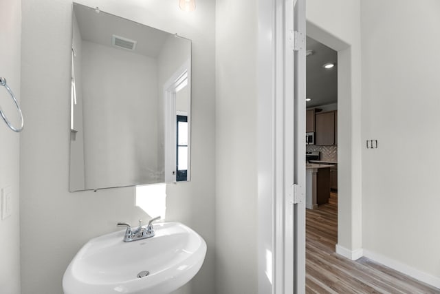 21624 Alberta Forest Cir, Magnolia, TX 77355 - bathroom featuring wood finished floors and decorative backsplash