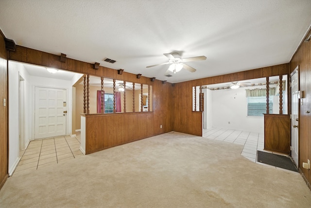 9506 Kell Cir, Houston, TX 77040 - empty room featuring a ceiling fan, light carpet, wood walls, a textured ceiling, and light tile patterned floors
