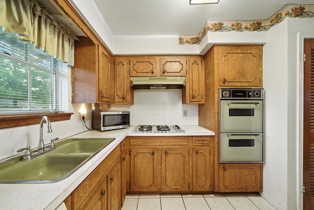 9506 Kell Cir, Houston, TX 77040 - kitchen with stainless steel microwave, multiple ovens, gas cooktop, under cabinet range hood, and brown cabinets