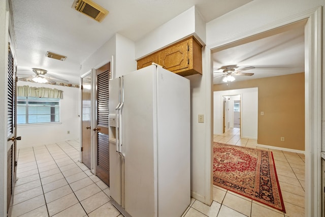 9506 Kell Cir, Houston, TX 77040 - kitchen featuring white refrigerator with ice dispenser, a ceiling fan, light tile patterned flooring, and brown cabinetry