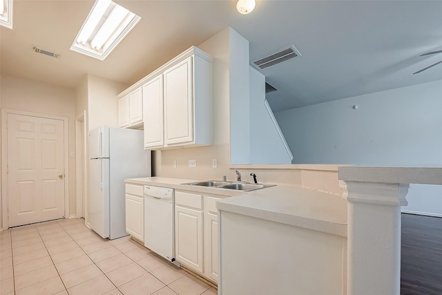 14 Scenic Brook Ct, The Woodlands, TX 77382 - kitchen with white appliances, a peninsula, light tile patterned floors, white cabinets, and light countertops