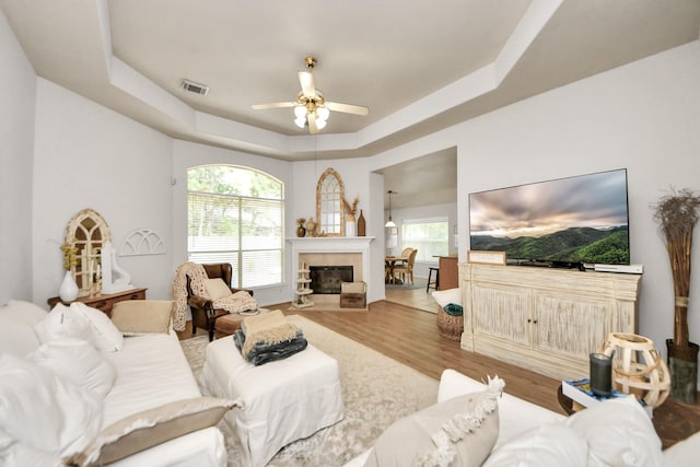 70 N Lace Arbor Dr, The Woodlands, TX 77382 - living area featuring a raised ceiling, a ceiling fan, wood finished floors, and plenty of natural light