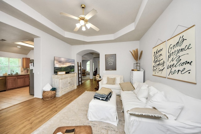 70 N Lace Arbor Dr, The Woodlands, TX 77382 - living room featuring arched walkways, a ceiling fan, plenty of natural light, and light wood-type flooring