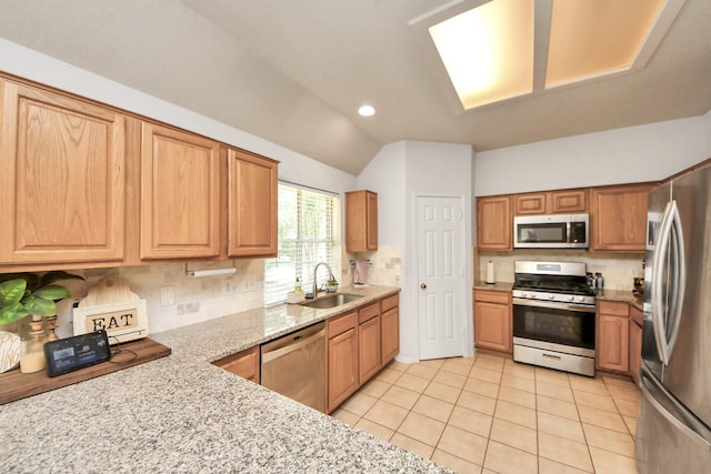 70 N Lace Arbor Dr, The Woodlands, TX 77382 - kitchen with stainless steel appliances, vaulted ceiling, tasteful backsplash, light tile patterned floors, and light stone countertops