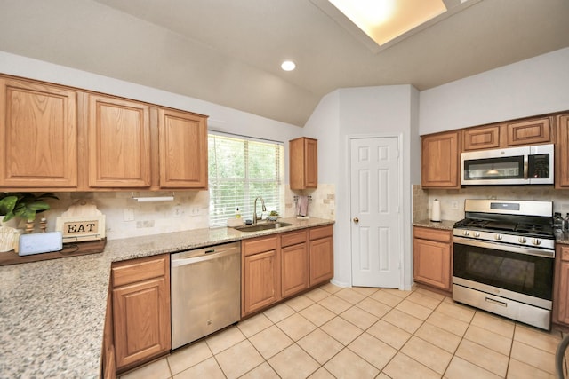 70 N Lace Arbor Dr, The Woodlands, TX 77382 - kitchen featuring stainless steel appliances, backsplash, vaulted ceiling, light tile patterned floors, and light stone counters
