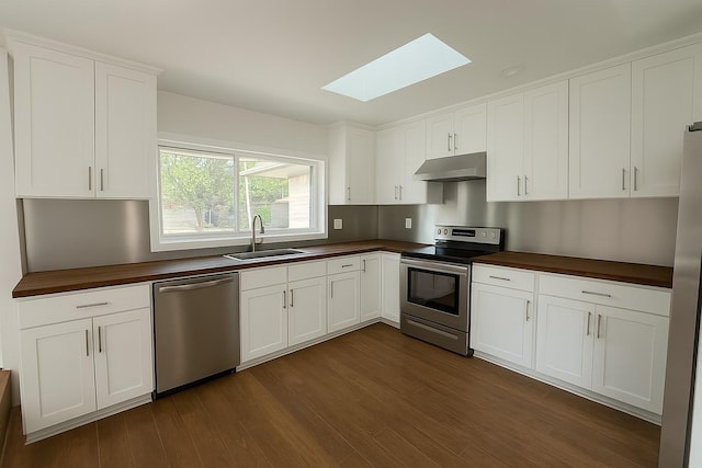 7810 Nairn St, Houston, TX 77074 - kitchen with stainless steel appliances, under cabinet range hood, a skylight, and butcher block counters