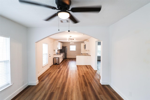2120 Yates St, Houston, TX 77020 - unfurnished living room with arched walkways, dark wood-style floors, and ceiling fan
