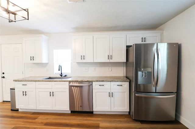 2120 Yates St, Houston, TX 77020 - kitchen with stainless steel appliances, white cabinetry, light stone counters, and light wood-type flooring