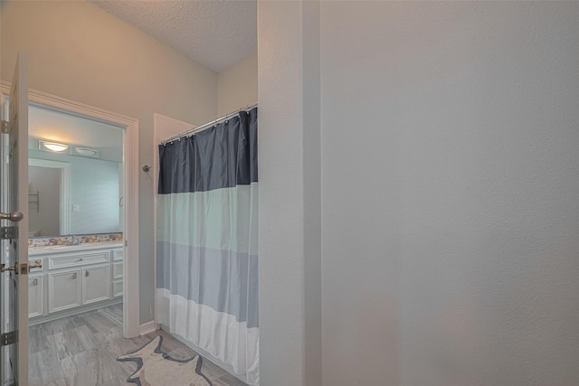 4006 Lanark Ln, Houston, TX 77025 - bathroom with vanity, a shower with curtain, and a textured ceiling