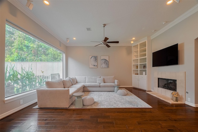 4006 Lanark Ln, Houston, TX 77025 - living room with healthy amount of natural light, ornamental molding, hardwood / wood-style flooring, a tiled fireplace, and a ceiling fan