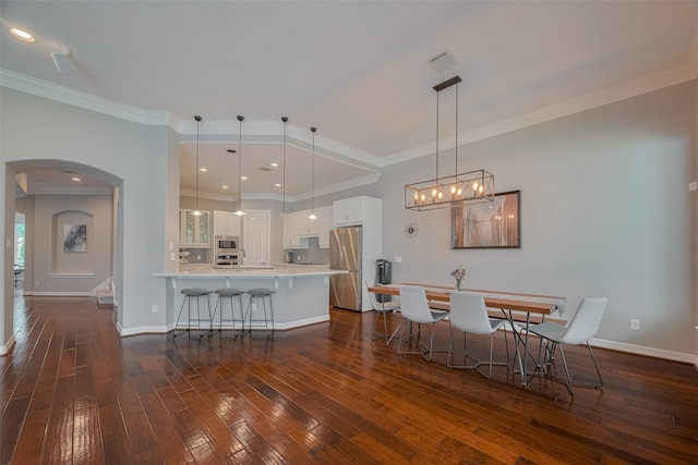 4006 Lanark Ln, Houston, TX 77025 - dining area featuring arched walkways, dark wood-type flooring, and crown molding