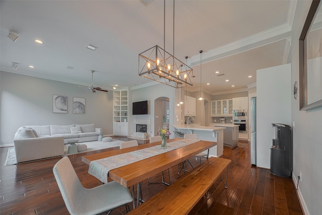 4006 Lanark Ln, Houston, TX 77025 - dining room featuring ornamental molding, dark wood finished floors, arched walkways, ceiling fan, and recessed lighting