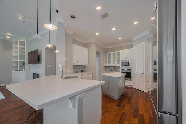 4006 Lanark Ln, Houston, TX 77025 - kitchen featuring stainless steel appliances, crown molding, a peninsula, arched walkways, and dark wood-type flooring