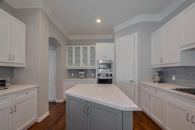 4006 Lanark Ln, Houston, TX 77025 - kitchen with appliances with stainless steel finishes, decorative backsplash, recessed lighting, dark wood-style flooring, and white cabinets