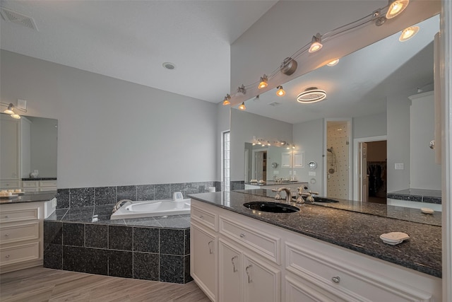 4006 Lanark Ln, Houston, TX 77025 - bathroom featuring a garden tub, vanity, and wood finished floors