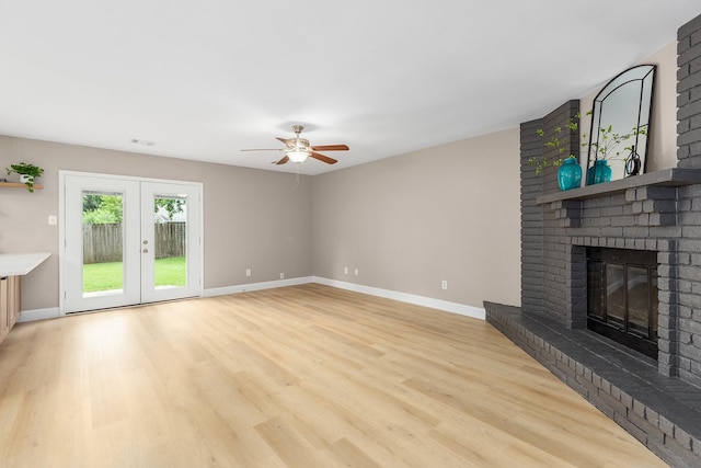 2807 Canary Ln, Humble, TX 77396 - unfurnished living room with a fireplace, a ceiling fan, light wood-style flooring, and french doors