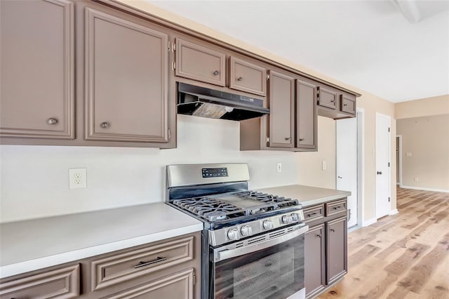 507 Odessa Dr, Magnolia, TX 77354 - kitchen with stainless steel range with gas cooktop, under cabinet range hood, light countertops, and light wood finished floors