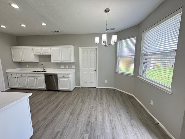 4607 Blue Rose Cir, Missouri City, TX 77459 - kitchen with stainless steel dishwasher, light countertops, a chandelier, wood finished floors, and recessed lighting