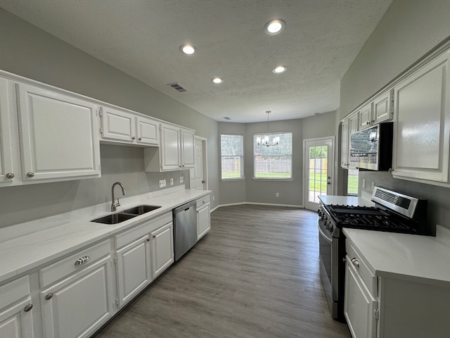 4607 Blue Rose Cir, Missouri City, TX 77459 - kitchen featuring stainless steel appliances, recessed lighting, a textured ceiling, a chandelier, and white cabinets
