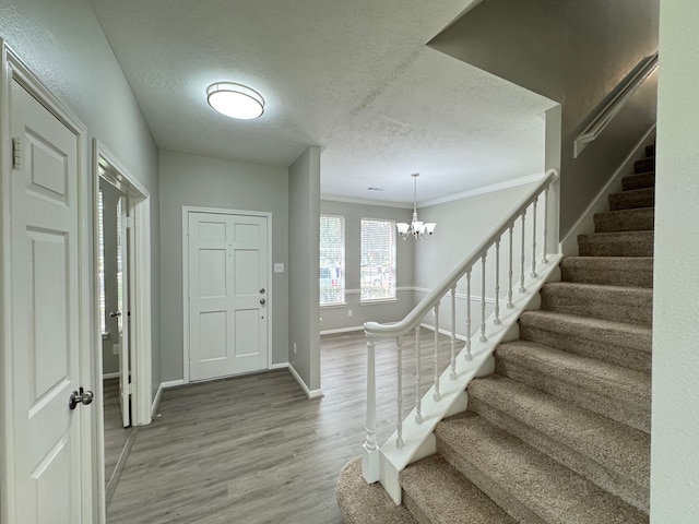 4607 Blue Rose Cir, Missouri City, TX 77459 - entryway with a textured ceiling, stairs, wood finished floors, a chandelier, and ornamental molding