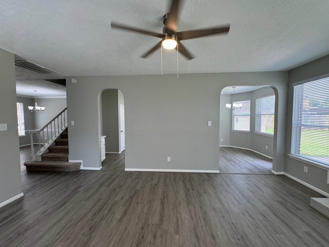 4607 Blue Rose Cir, Missouri City, TX 77459 - unfurnished living room featuring a chandelier, arched walkways, dark wood finished floors, a textured ceiling, and ceiling fan