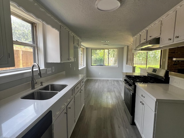7726 Ashmole Ln, Houston, TX 77088 - kitchen featuring stainless steel appliances, a textured ceiling, dark wood-style floors, light countertops, and under cabinet range hood