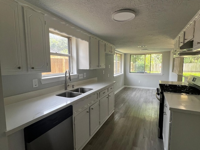 7726 Ashmole Ln, Houston, TX 77088 - kitchen featuring appliances with stainless steel finishes, under cabinet range hood, light countertops, dark wood-style floors, and a textured ceiling