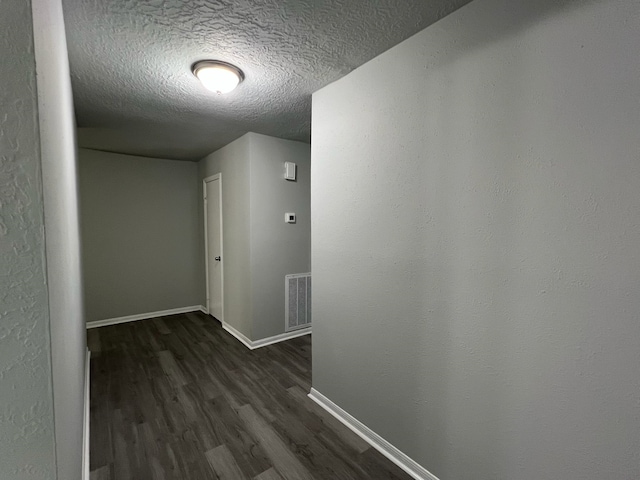 7726 Ashmole Ln, Houston, TX 77088 - hallway featuring dark wood-type flooring and a textured ceiling