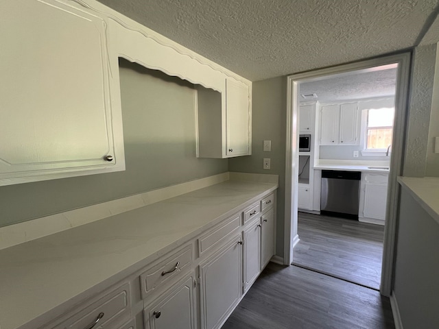 7726 Ashmole Ln, Houston, TX 77088 - kitchen featuring appliances with stainless steel finishes, a textured ceiling, white cabinetry, dark wood-style flooring, and light countertops