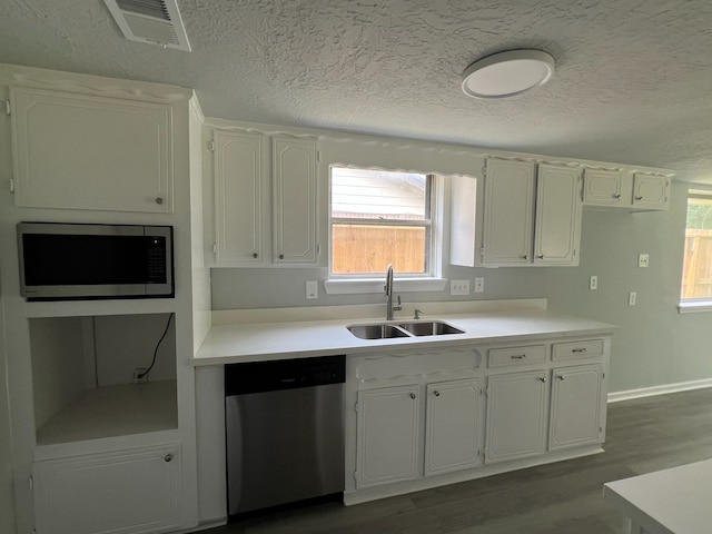 7726 Ashmole Ln, Houston, TX 77088 - kitchen with appliances with stainless steel finishes, white cabinets, dark wood finished floors, light countertops, and a textured ceiling