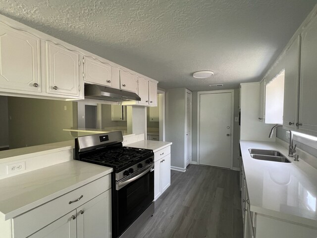 7726 Ashmole Ln, Houston, TX 77088 - kitchen featuring stainless steel range with gas stovetop, under cabinet range hood, white cabinets, dark wood-style floors, and a textured ceiling