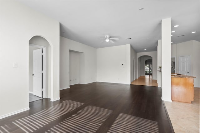 11047 Pierce Valley Dr, Richmond, TX 77406 - unfurnished living room with arched walkways, a ceiling fan, and light wood-type flooring