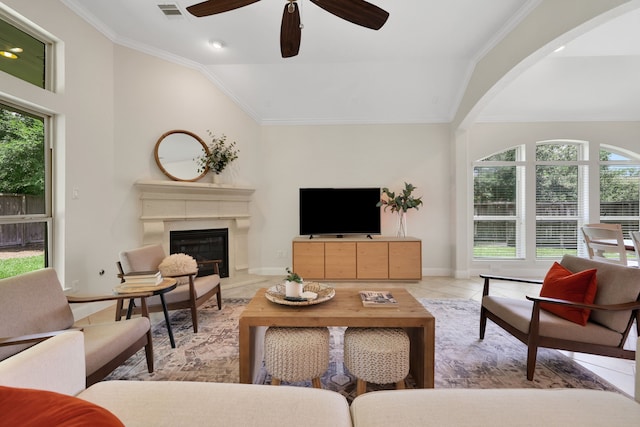 18774 Monetta Dr, New Caney, TX 77357 - living room with a glass covered fireplace, a ceiling fan, lofted ceiling, ornamental molding, and arched walkways