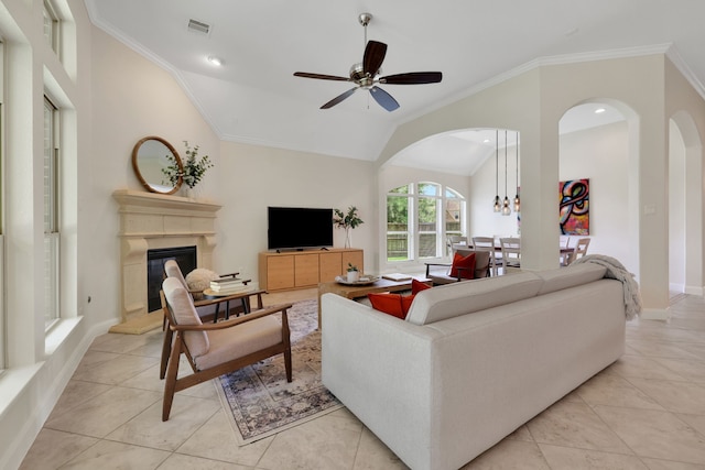 18774 Monetta Dr, New Caney, TX 77357 - living room featuring lofted ceiling, a glass covered fireplace, a ceiling fan, light tile patterned floors, and ornamental molding
