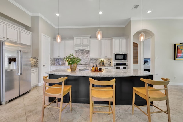 18774 Monetta Dr, New Caney, TX 77357 - kitchen with appliances with stainless steel finishes, tasteful backsplash, arched walkways, white cabinets, and crown molding