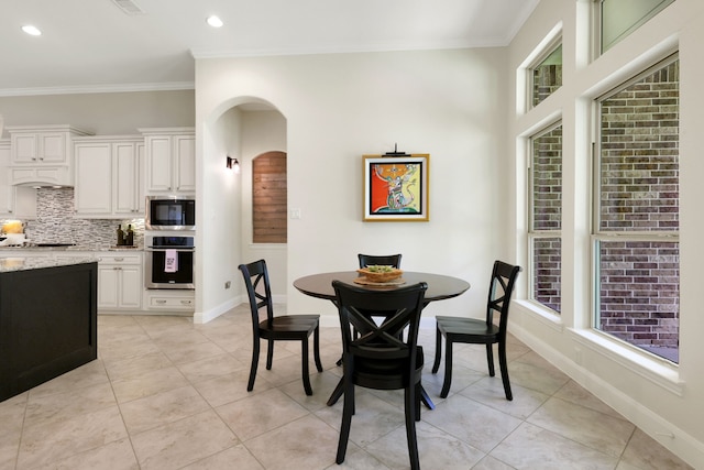 18774 Monetta Dr, New Caney, TX 77357 - dining room with light tile patterned floors, arched walkways, ornamental molding, and recessed lighting
