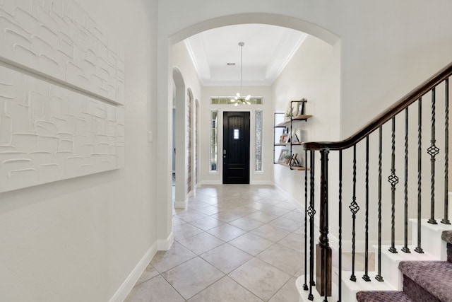 18774 Monetta Dr, New Caney, TX 77357 - entryway featuring arched walkways, crown molding, a chandelier, light tile patterned flooring, and stairway