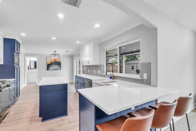 2504 Leroy St, Pearland, TX 77581 - kitchen with a center island, blue cabinets, light countertops, appliances with stainless steel finishes, and crown molding
