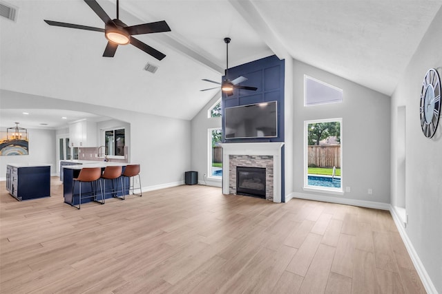 2504 Leroy St, Pearland, TX 77581 - living area with a ceiling fan, high vaulted ceiling, a stone fireplace, light wood finished floors, and beamed ceiling