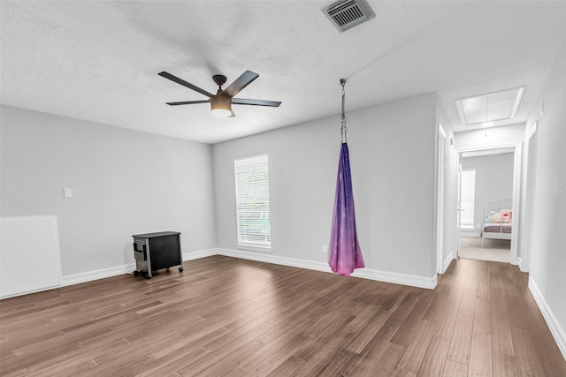 2504 Leroy St, Pearland, TX 77581 - unfurnished living room with attic access, a ceiling fan, wood finished floors, and a textured ceiling