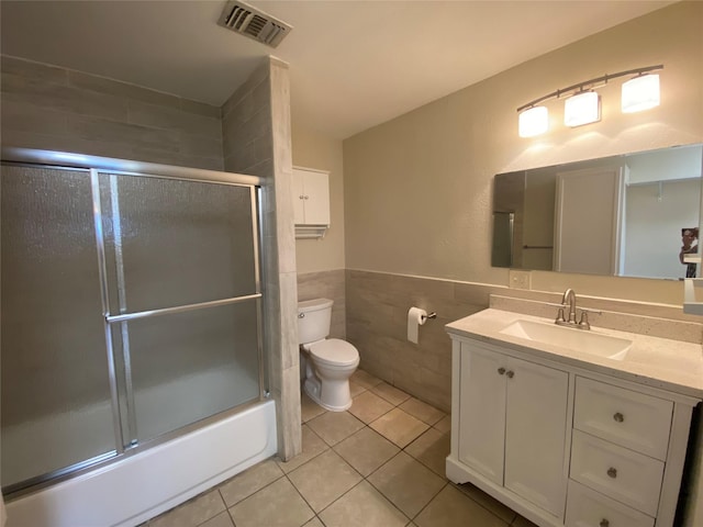2512 Pine St, Galveston, TX 77551 - bathroom featuring tile walls, tile patterned floors, vanity, shower / bath combination with glass door, and wainscoting