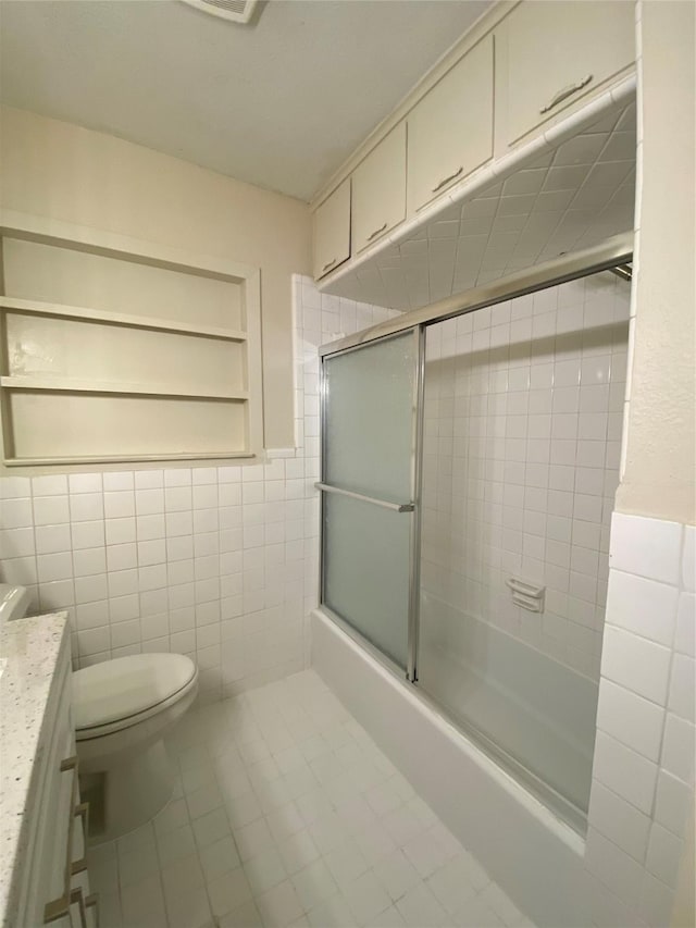 2512 Pine St, Galveston, TX 77551 - full bath with tile walls, vanity, tile patterned floors, and enclosed tub / shower combo