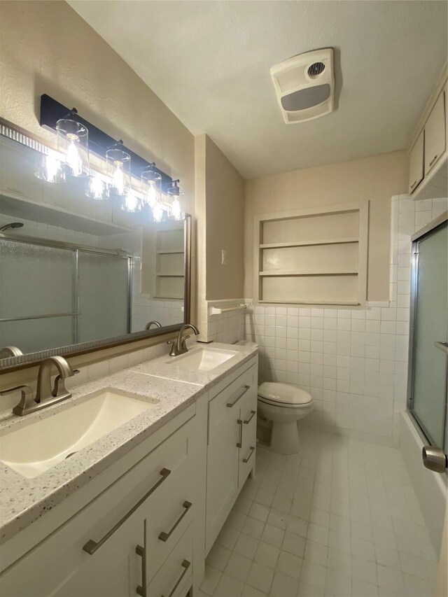 2512 Pine St, Galveston, TX 77551 - bathroom with tile walls, tile patterned floors, a shower with shower door, and double vanity