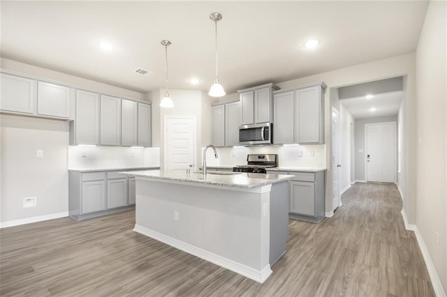 828 Laguna Green Ln, Katy, TX 77493 - kitchen with stainless steel appliances, gray cabinets, light wood-style floors, decorative backsplash, and recessed lighting